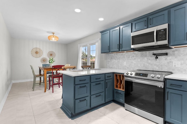 2311 S Golden Ave, Springfield, MO 65807 - kitchen featuring stainless steel appliances, a peninsula, light countertops, backsplash, and light tile patterned floors