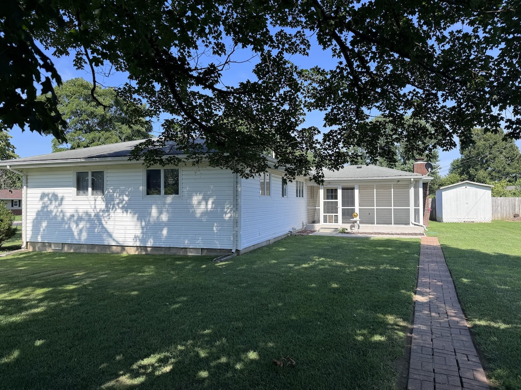 104 E Meadowbrook Ave, Clever, MO 65631 - rear view of house featuring a shed, a sunroom, a lawn, and a chimney