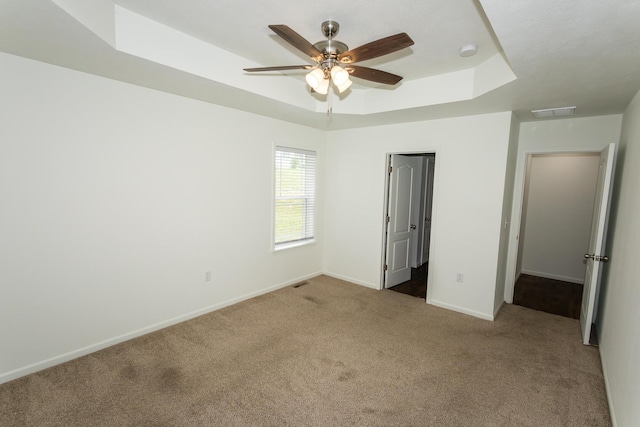 297 Kelsi Ln, Branson, MO 65616 - unfurnished bedroom featuring carpet floors, a raised ceiling, and ceiling fan