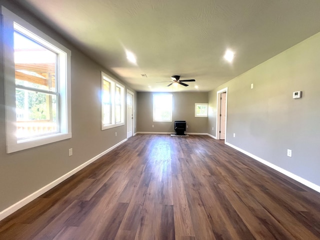 711 W Woodbine Rd, Ash Grove, MO 65604 - unfurnished living room featuring a wood stove, ceiling fan, and dark wood-style flooring
