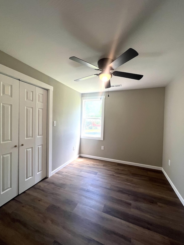 711 W Woodbine Rd, Ash Grove, MO 65604 - unfurnished bedroom featuring dark wood-style flooring, a closet, and a ceiling fan