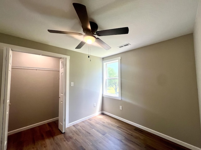711 W Woodbine Rd, Ash Grove, MO 65604 - unfurnished bedroom with wood finished floors, a ceiling fan, and a closet