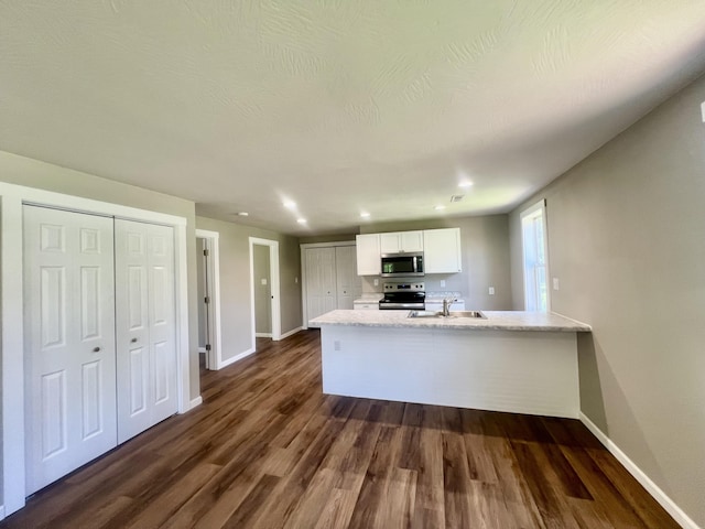 711 W Woodbine Rd, Ash Grove, MO 65604 - kitchen featuring stainless steel appliances, white cabinets, dark wood finished floors, light stone counters, and recessed lighting