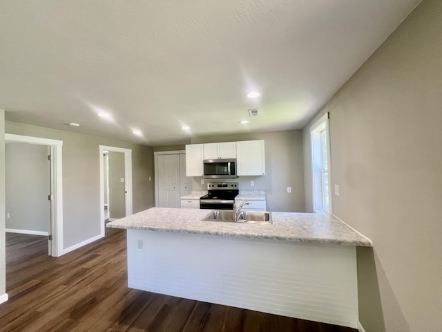 711 W Woodbine Rd, Ash Grove, MO 65604 - kitchen featuring appliances with stainless steel finishes, dark wood-type flooring, white cabinetry, recessed lighting, and a peninsula