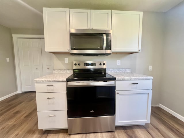711 W Woodbine Rd, Ash Grove, MO 65604 - kitchen with stainless steel appliances, light wood-style flooring, and light countertops