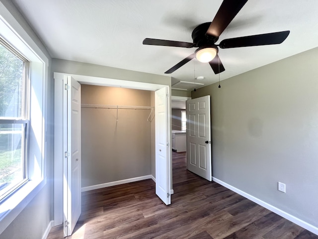 711 W Woodbine Rd, Ash Grove, MO 65604 - unfurnished bedroom with multiple windows, dark wood-type flooring, and a closet