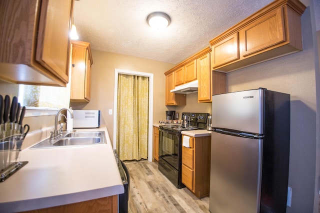 602 E Robertson, Ozark, MO 65721 - kitchen with freestanding refrigerator, black / electric stove, under cabinet range hood, light wood-type flooring, and a textured ceiling