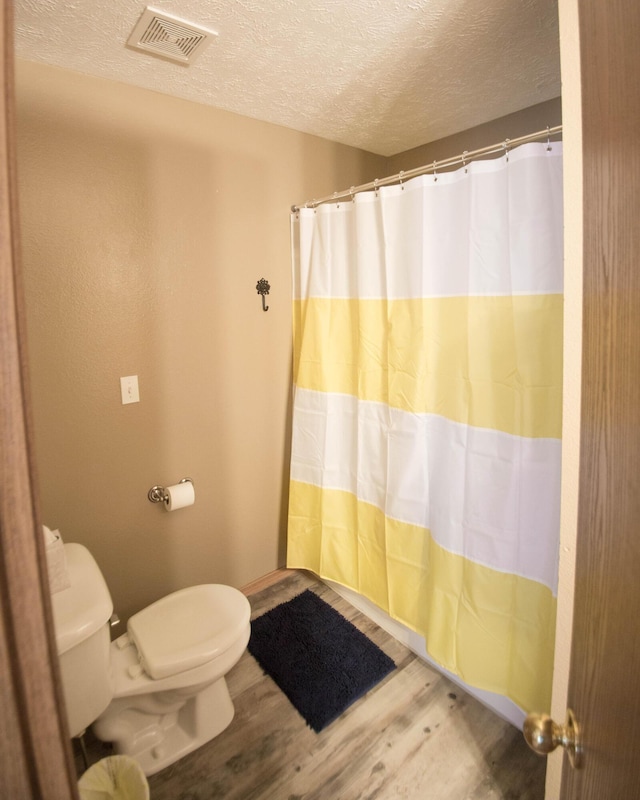 602 E Robertson, Ozark, MO 65721 - bathroom with wood finished floors, a textured ceiling, and curtained shower