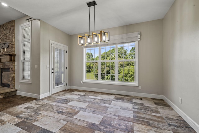 5323 S Carson St, Battlefield, MO 65619 - unfurnished dining area with a fireplace, a chandelier, and stone finish flooring