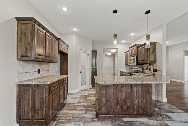 5323 S Carson St, Battlefield, MO 65619 - kitchen with stainless steel appliances, a peninsula, light stone countertops, dark brown cabinetry, and recessed lighting
