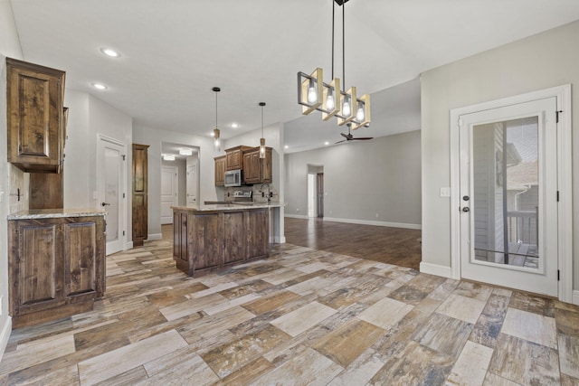 5323 S Carson St, Battlefield, MO 65619 - kitchen with stainless steel appliances, open floor plan, light wood-type flooring, pendant lighting, and light stone countertops