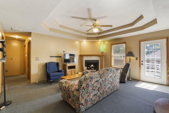 508 N Cherry Cir, Nixa, MO 65714 - carpeted living area featuring a raised ceiling, ceiling fan, a textured ceiling, and a tile fireplace
