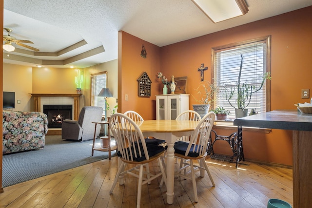 508 N Cherry Cir, Nixa, MO 65714 - dining area featuring wood-type flooring, a tiled fireplace, and a ceiling fan