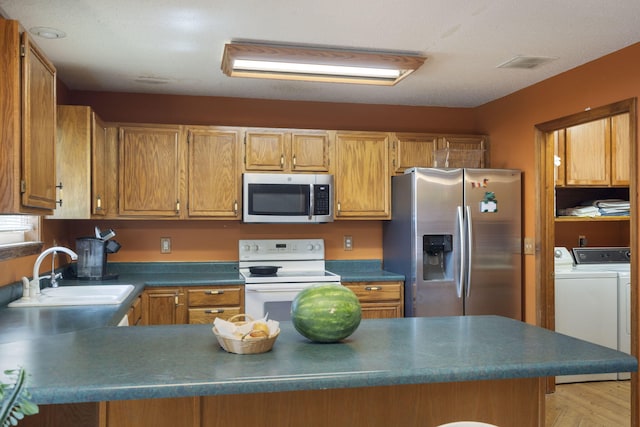 508 N Cherry Cir, Nixa, MO 65714 - kitchen with stainless steel appliances, independent washer and dryer, dark countertops, a peninsula, and brown cabinetry