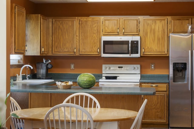 508 N Cherry Cir, Nixa, MO 65714 - kitchen with stainless steel appliances, dark countertops, and brown cabinetry