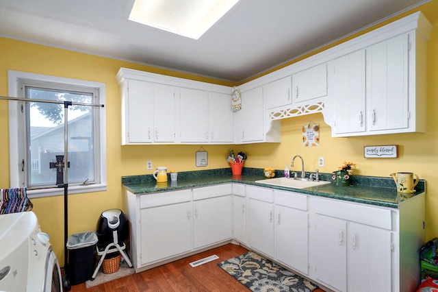 1343 Woodlawn Ave, Mount Vernon, MO 65712 - kitchen featuring independent washer and dryer, dark countertops, wood finished floors, and white cabinetry