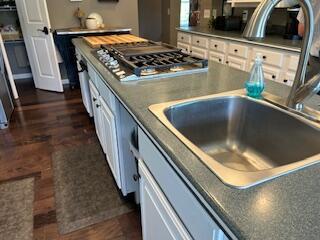 134 Meadowbrook Ln, Walnut Shade, MO 65771 - kitchen with stainless steel gas stovetop, white cabinetry, dark wood-type flooring, and dark countertops