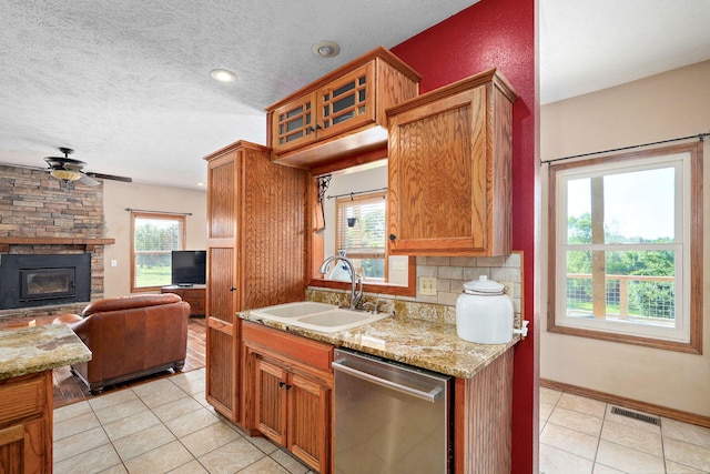 8404 Fossilsaurus Ln, Ash Grove, MO 65604 - kitchen with stainless steel dishwasher, light tile patterned floors, ceiling fan, open floor plan, and a textured ceiling