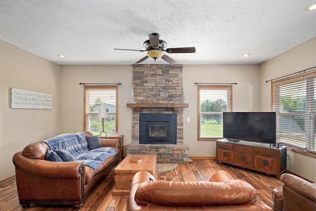 8404 Fossilsaurus Ln, Ash Grove, MO 65604 - living room featuring hardwood / wood-style floors, a ceiling fan, plenty of natural light, a textured ceiling, and a fireplace