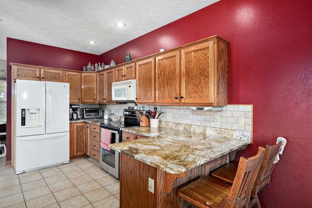 8404 Fossilsaurus Ln, Ash Grove, MO 65604 - kitchen featuring white appliances, brown cabinetry, backsplash, a peninsula, and light stone countertops
