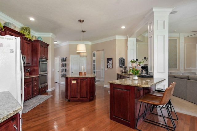 1776 S Gregg Rd, Nixa, MO 65714 - kitchen with reddish brown cabinets, double oven, dark wood-style floors, pendant lighting, and ornamental molding