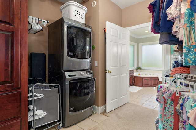 1776 S Gregg Rd, Nixa, MO 65714 - laundry room with estacked washer and dryer, light tile patterned flooring, ornamental molding, and light carpet