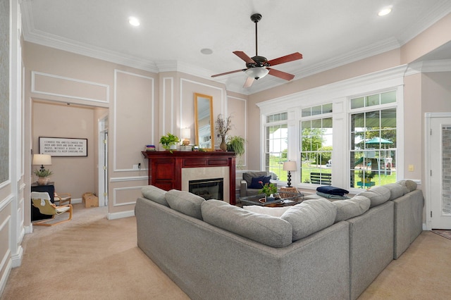 1776 S Gregg Rd, Nixa, MO 65714 - living room featuring a tiled fireplace, ceiling fan, ornamental molding, a decorative wall, and light colored carpet