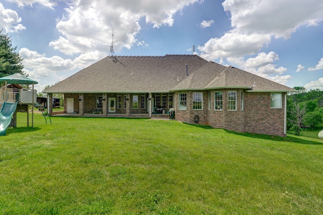 1776 S Gregg Rd, Nixa, MO 65714 - rear view of house featuring a playground, a yard, brick siding, and a shingled roof