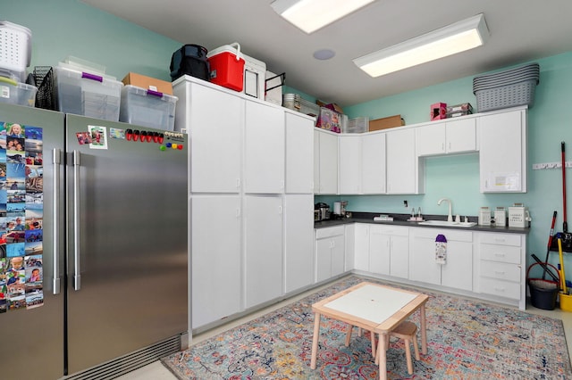 1776 S Gregg Rd, Nixa, MO 65714 - kitchen with freestanding refrigerator, white cabinetry, and dark countertops