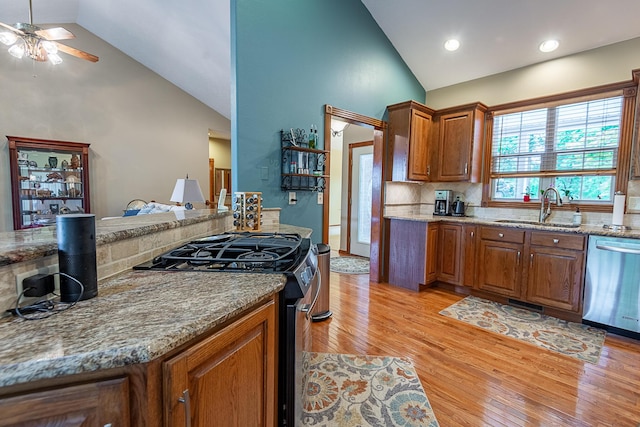 280 Center Rd, Ozark, MO 65721 - kitchen with appliances with stainless steel finishes, a ceiling fan, brown cabinetry, light wood-style floors, and high vaulted ceiling
