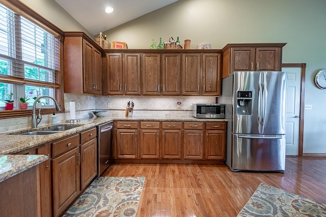 280 Center Rd, Ozark, MO 65721 - kitchen with appliances with stainless steel finishes, vaulted ceiling, tasteful backsplash, light wood finished floors, and light stone countertops