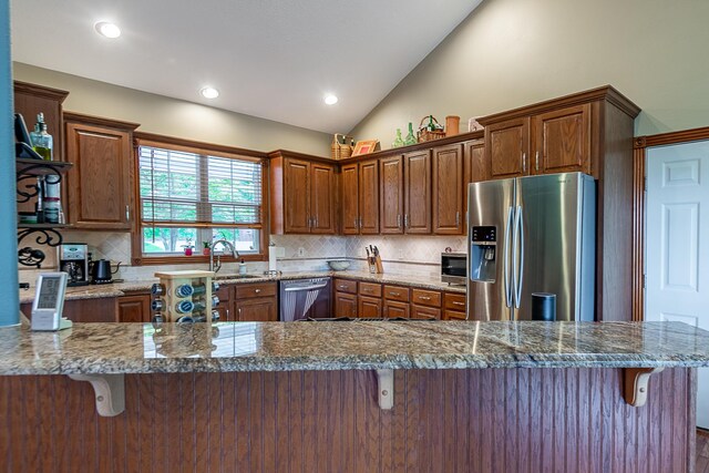 280 Center Rd, Ozark, MO 65721 - kitchen featuring stainless steel appliances, a kitchen bar, vaulted ceiling, tasteful backsplash, and recessed lighting