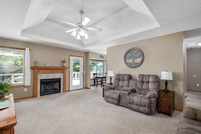 3605 N 30th St, Ozark, MO 65721 - living room with a raised ceiling, carpet, a tile fireplace, a ceiling fan, and a textured ceiling