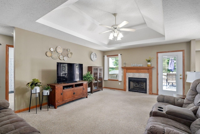 3605 N 30th St, Ozark, MO 65721 - living room with a raised ceiling, ceiling fan, light carpet, a tile fireplace, and a textured ceiling