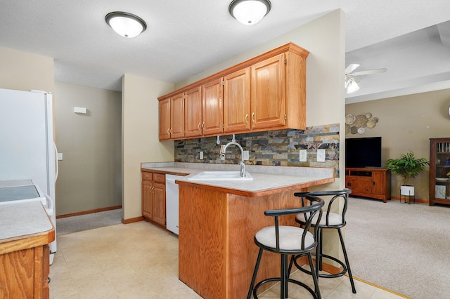 3605 N 30th St, Ozark, MO 65721 - kitchen featuring white dishwasher, a kitchen breakfast bar, tasteful backsplash, light countertops, and a peninsula
