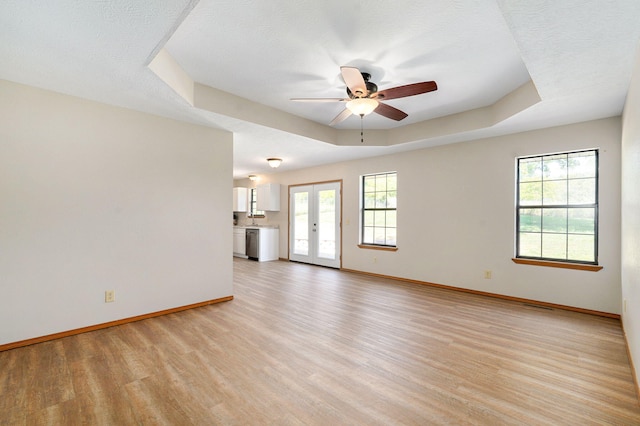 904 N 41st St, Nixa, MO 65714 - unfurnished living room with ceiling fan, light wood-style floors, plenty of natural light, and a tray ceiling