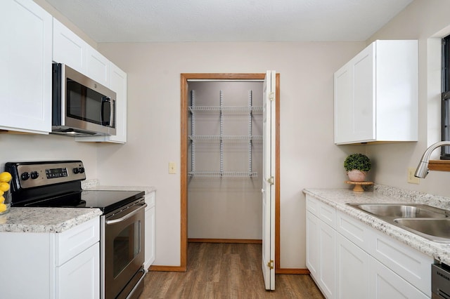 904 N 41st St, Nixa, MO 65714 - kitchen with stainless steel appliances, wood finished floors, light countertops, and white cabinets
