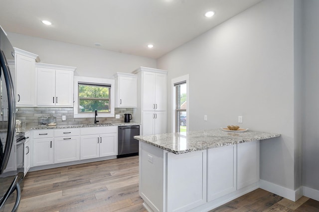 1240 E Keeling Pl, Bolivar, MO 65613 - kitchen with stainless steel appliances, a peninsula, white cabinets, tasteful backsplash, and light stone counters