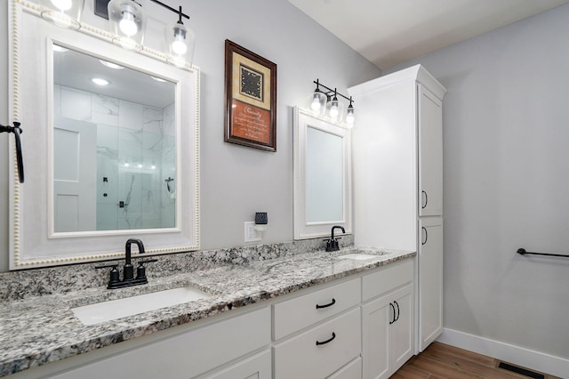 1240 E Keeling Pl, Bolivar, MO 65613 - bathroom featuring a marble finish shower, double vanity, and wood finished floors