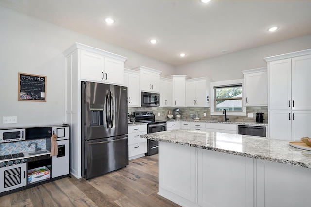 1240 E Keeling Pl, Bolivar, MO 65613 - kitchen featuring stainless steel appliances, white cabinets, decorative backsplash, dark wood-style floors, and recessed lighting