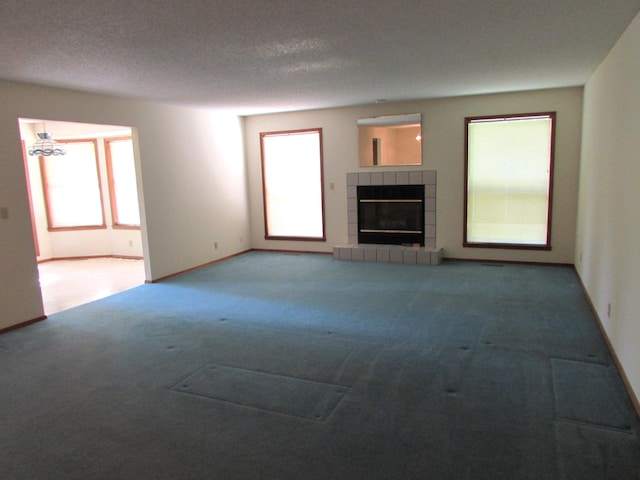 285 Scenic Dr, Forsyth, MO 65653 - unfurnished living room with carpet flooring, a tile fireplace, and a textured ceiling