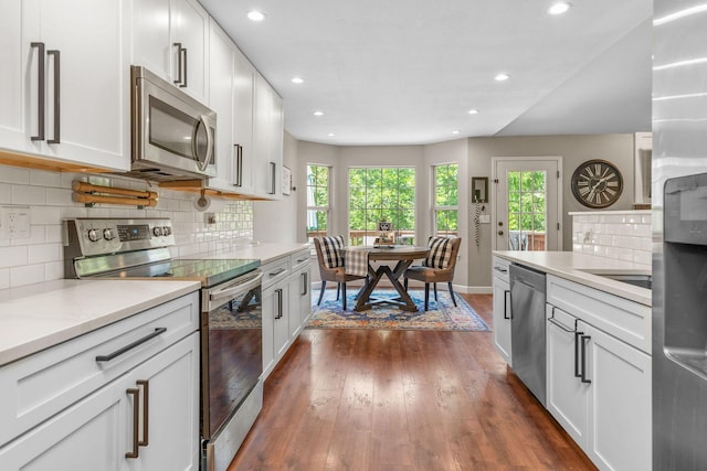 277 Country Bluff Dr, Branson, MO 65616 - kitchen with stainless steel appliances, dark wood-style floors, recessed lighting, decorative backsplash, and white cabinets