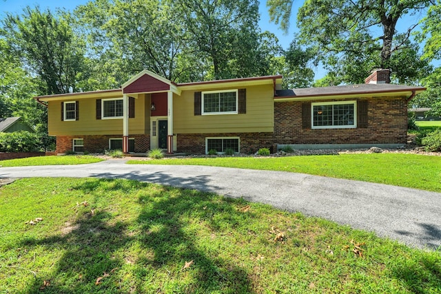 107 Oakwood Dr, Branson, MO 65616 - split foyer home with brick siding, a chimney, and a front lawn
