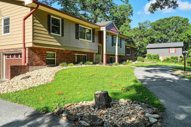 107 Oakwood Dr, Branson, MO 65616 - split foyer home featuring asphalt driveway, a garage, a front yard, and brick siding