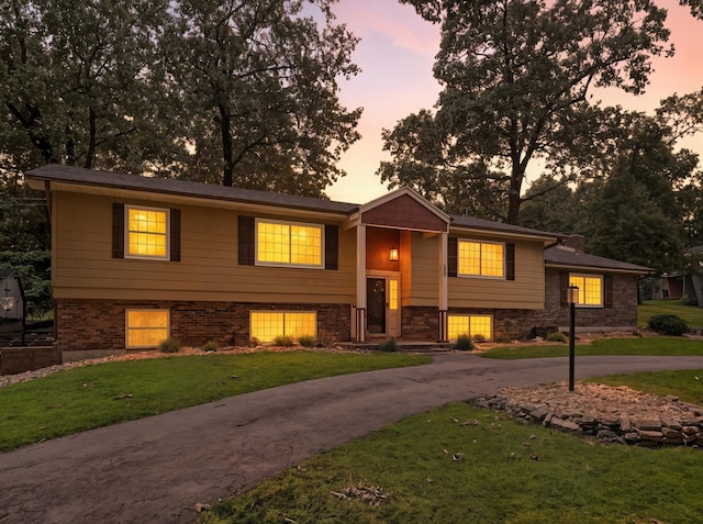 107 Oakwood Dr, Branson, MO 65616 - split foyer home featuring a yard, stone siding, and curved driveway