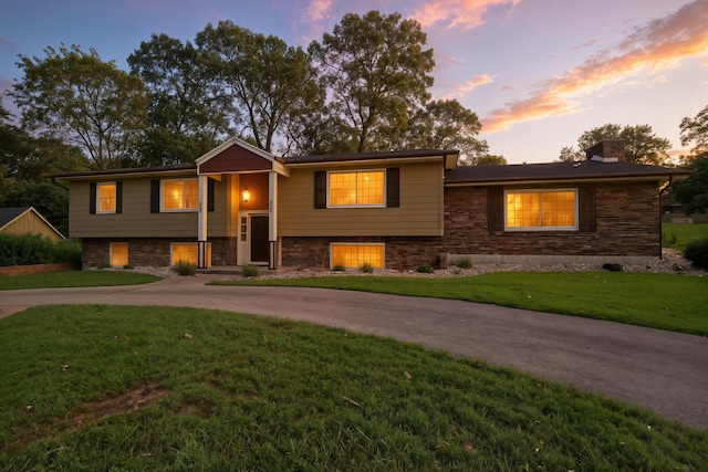 107 Oakwood Dr, Branson, MO 65616 - view of front of home featuring curved driveway, a yard, a chimney, and stone siding