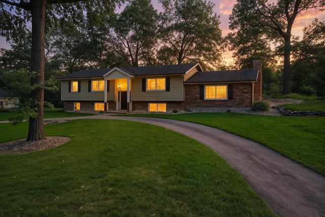 107 Oakwood Dr, Branson, MO 65616 - bi-level home featuring a chimney, curved driveway, and a yard