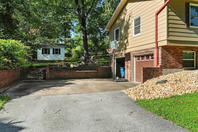 107 Oakwood Dr, Branson, MO 65616 - view of side of property with driveway, a garage, and brick siding