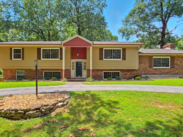 107 Oakwood Dr, Branson, MO 65616 - split foyer home featuring a front yard, brick siding, and curved driveway