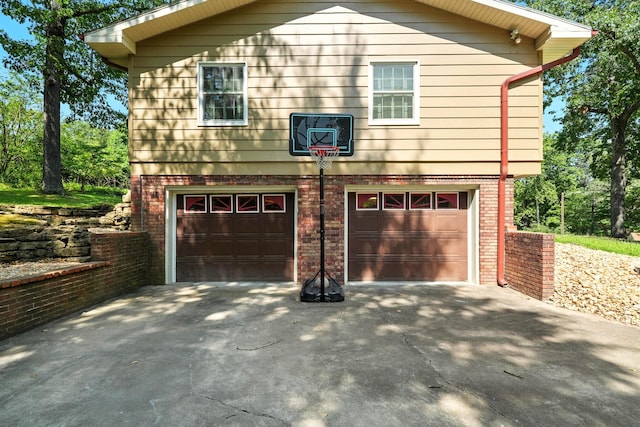 107 Oakwood Dr, Branson, MO 65616 - view of side of home featuring an attached garage, brick siding, and driveway